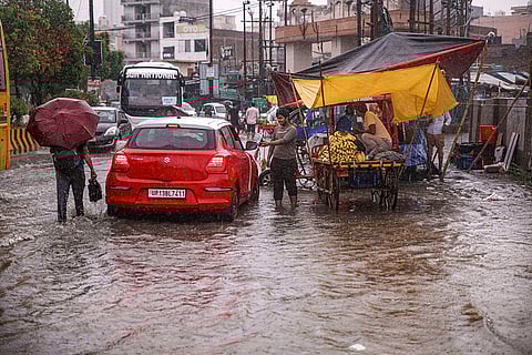 Commuters Wade through waterlogged road in Noida